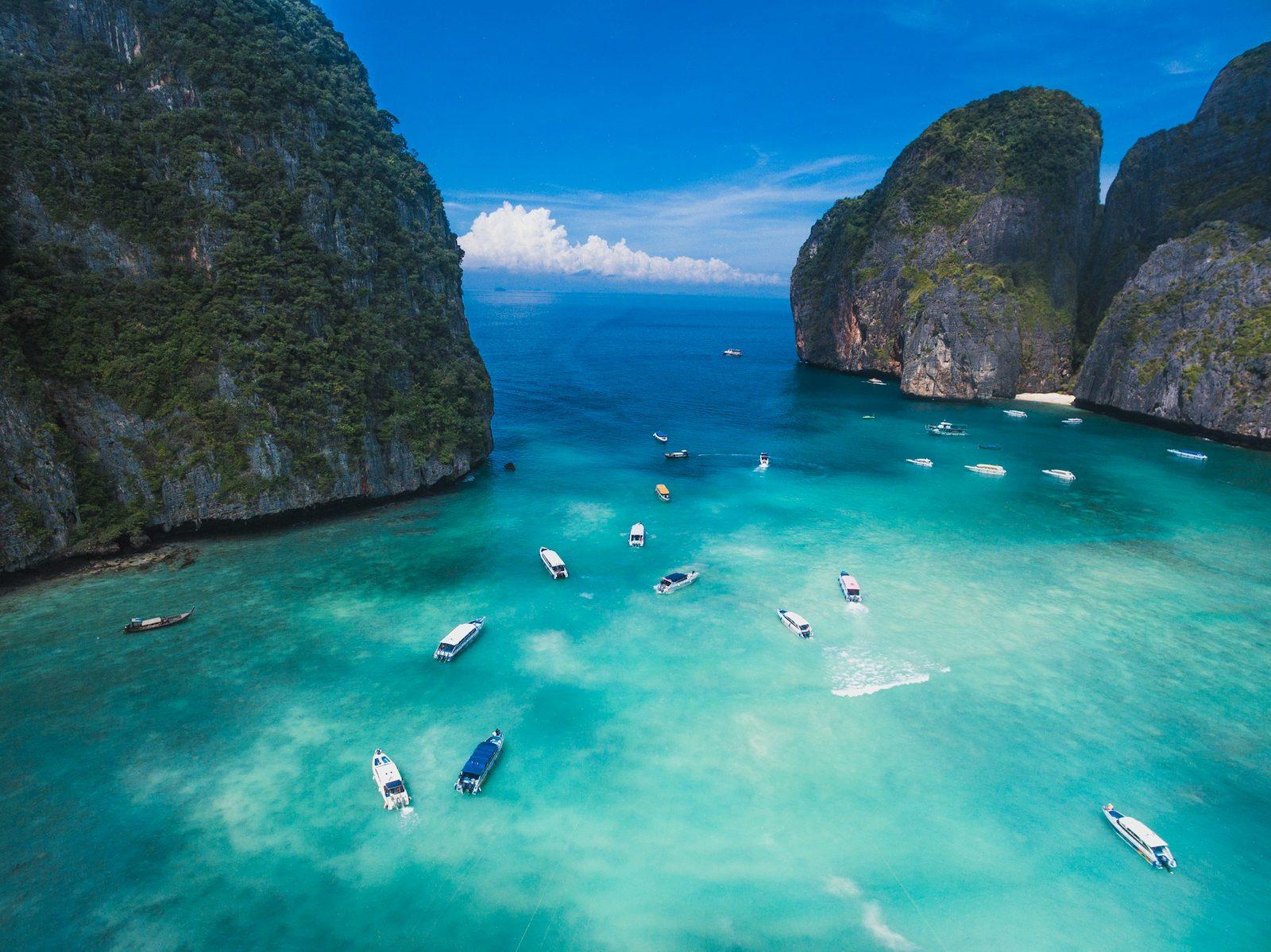 Türkisfarbene Bucht mit Booten zwischen Kalksteinfelsen, Maya Bay, Thailand
