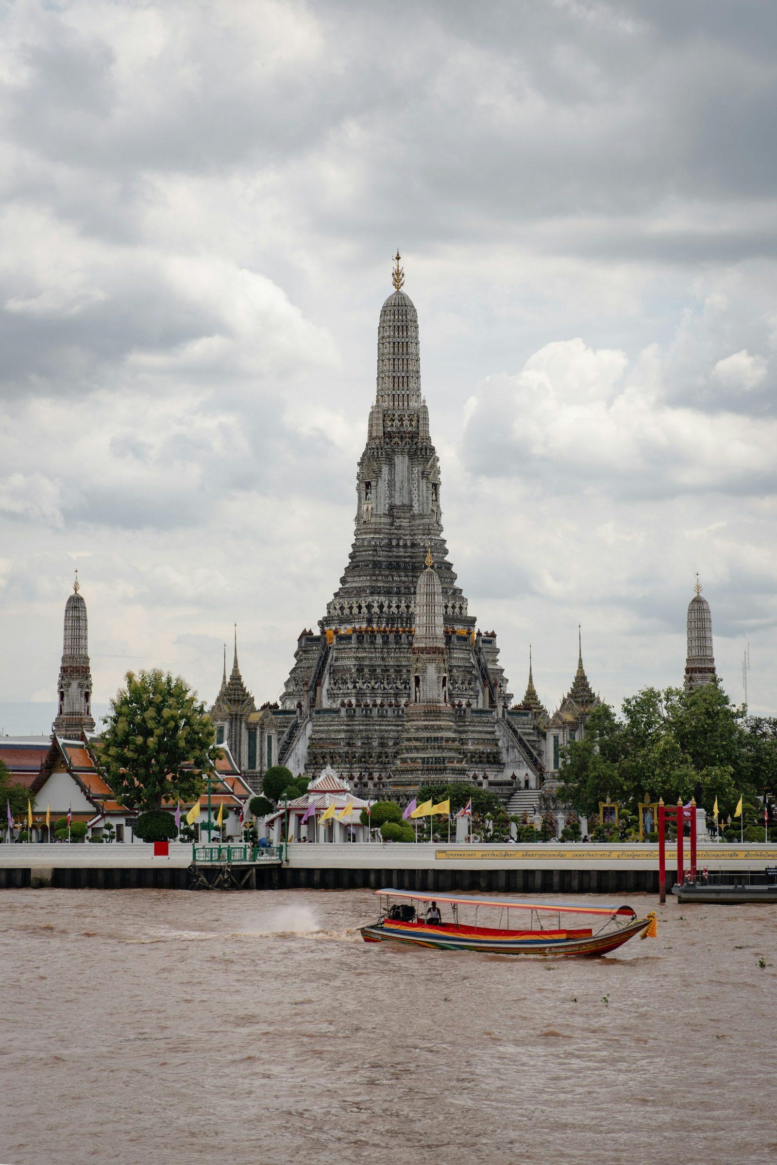 Wat-Arun-Tempel und ein Longtail-Boot auf dem Chao Phraya in Bangkok